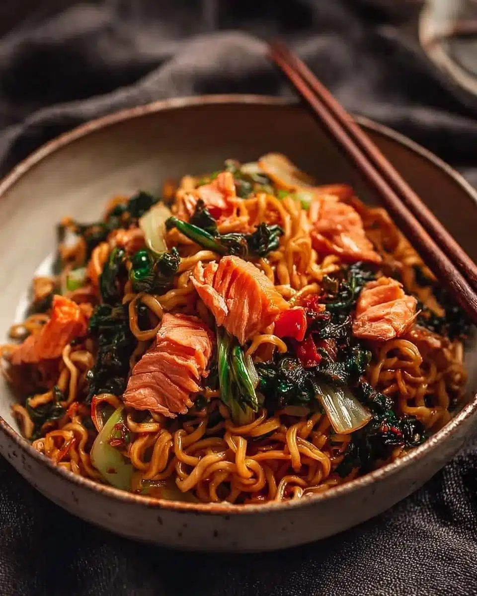 Teriyaki salmon served over a bed of noodles with vibrant vegetables.