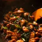 Plate of Thai Chilli Basil Chicken garnished with fresh basil leaves