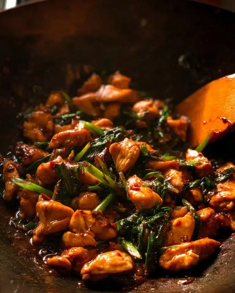 Plate of Thai Chilli Basil Chicken garnished with fresh basil leaves