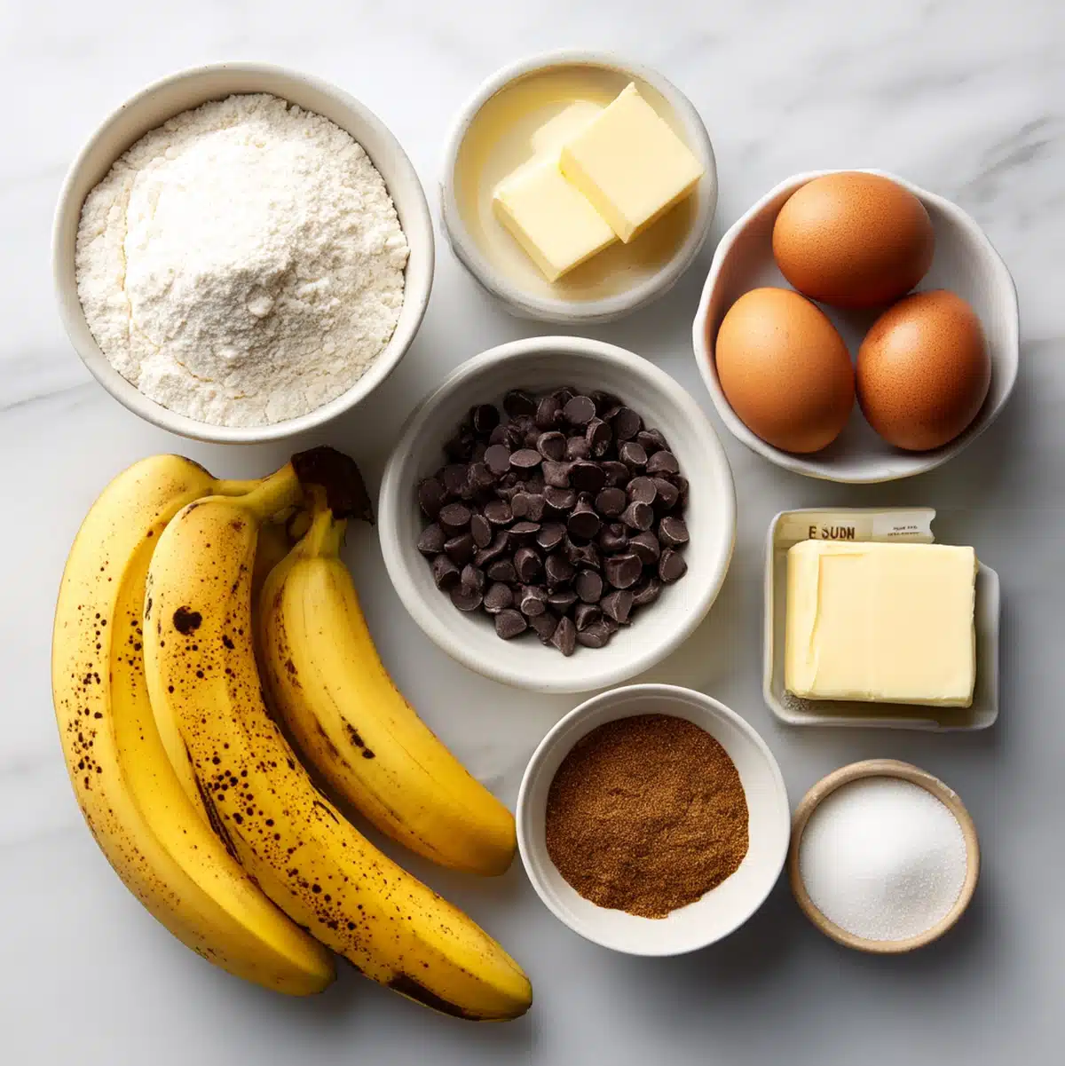 Banana chocolate chip cake ingredients flat lay with ripe bananas and muscovado sugar