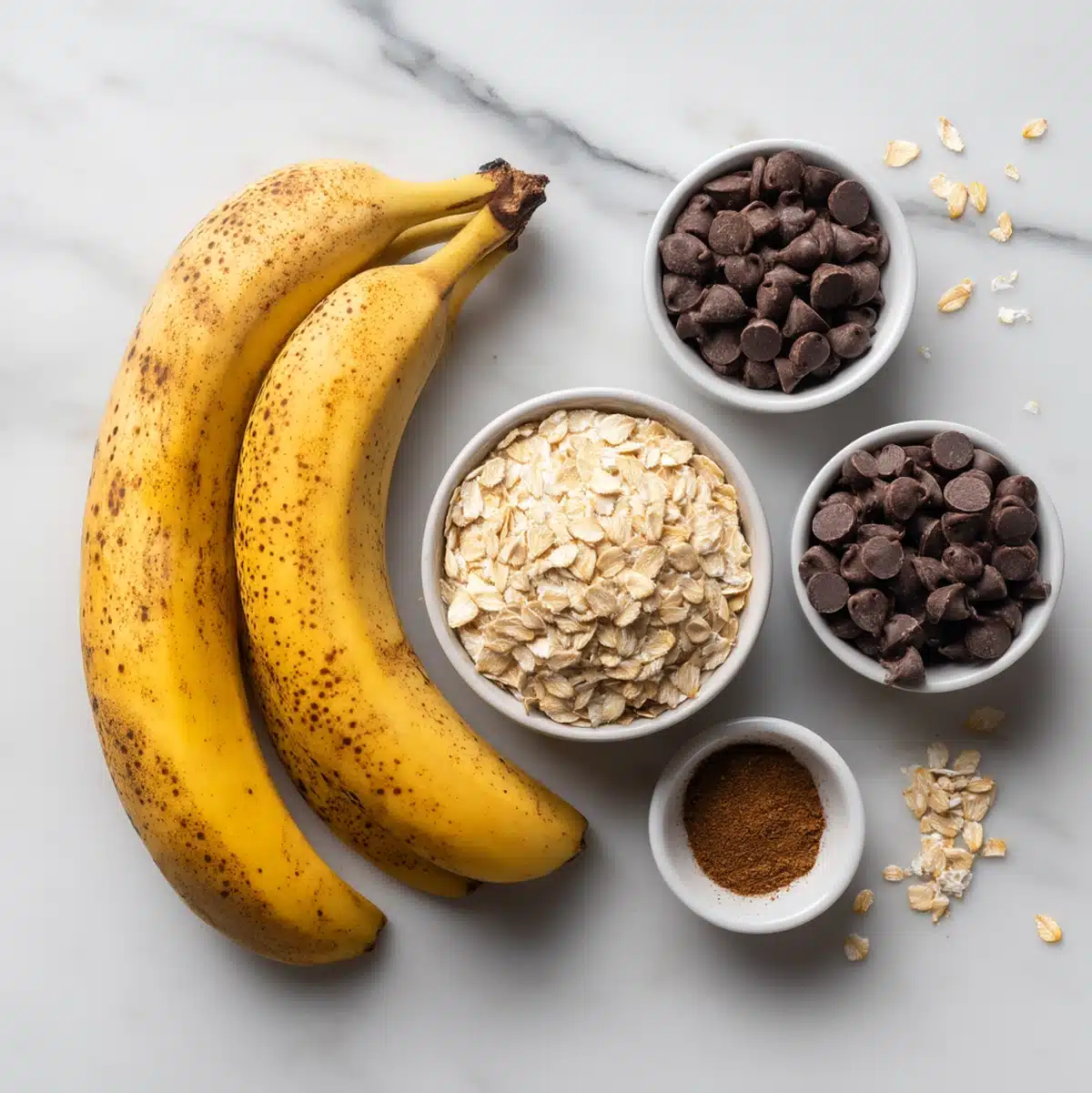 Banana chocolate chip oatmeal cookies ingredients flat-lay with oats, bananas and chocolate chips