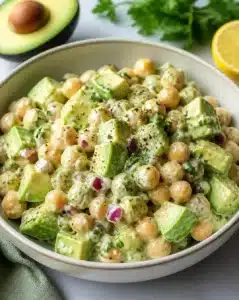 Chickpea and Avocado Salad 6 Chickpea avocado salad with fresh vegetables and dressing in a bowl