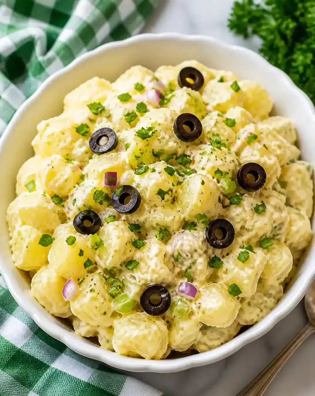Bowl of classic homemade potato salad with chopped veggies and creamy dressing