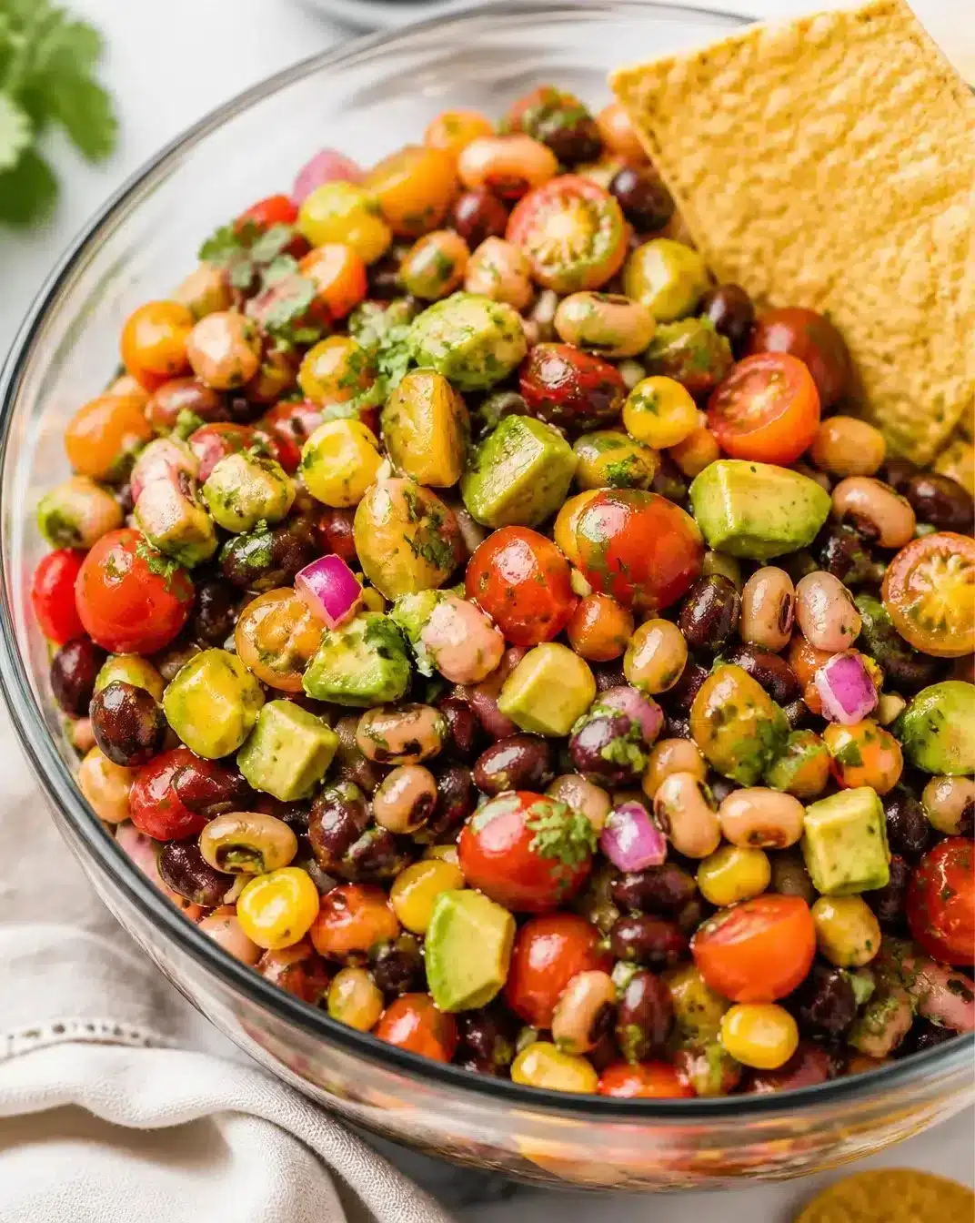 A colorful bowl of Cowboy Caviar featuring beans, corn, and avocado.