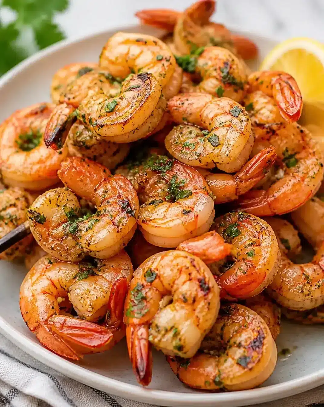 Plate of garlic-butter grilled shrimp with herbs and lemon