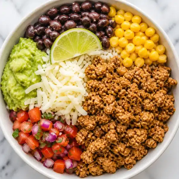 Delicious ground turkey rice bowl topped with fresh vegetables and sauces.