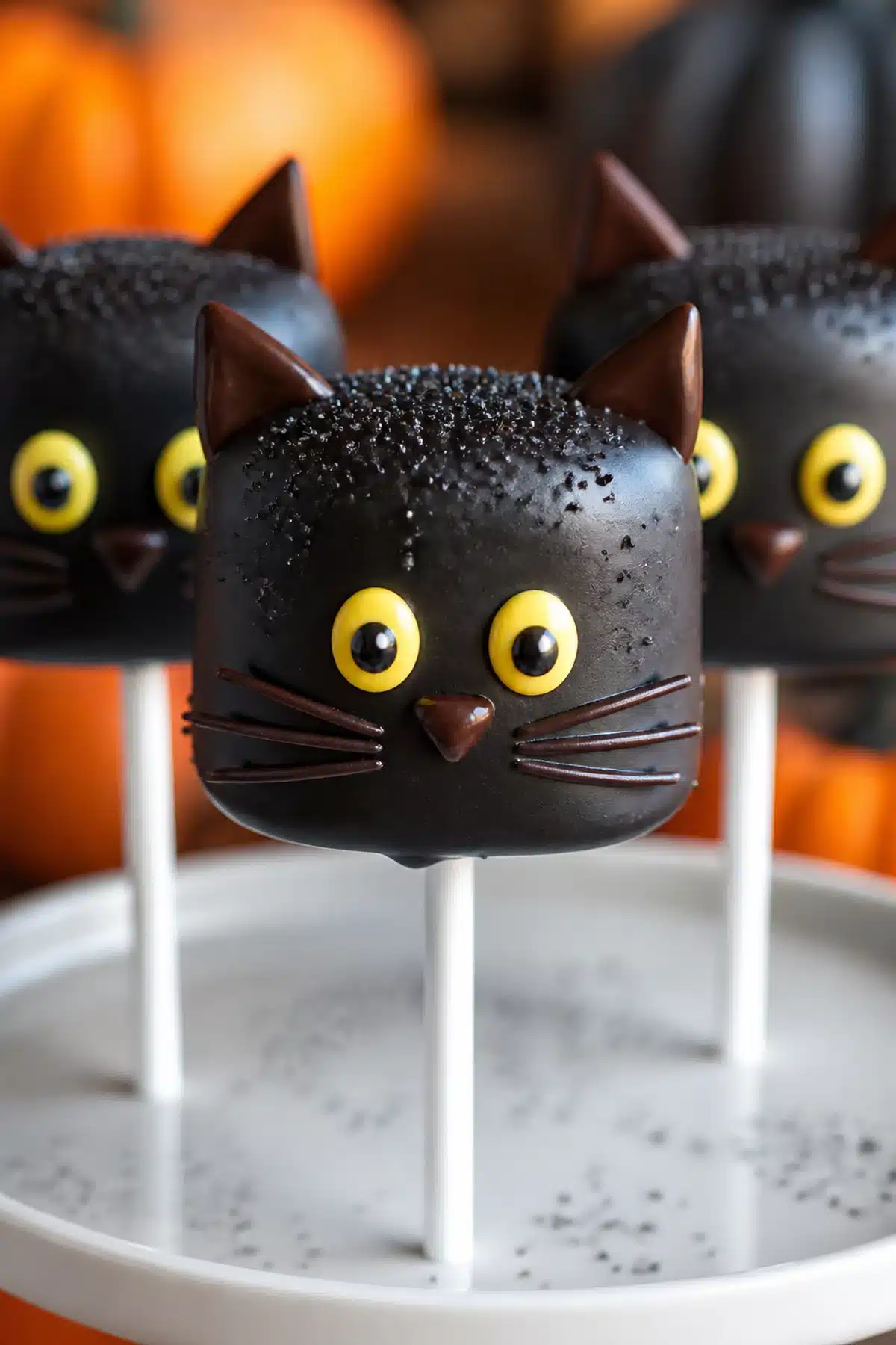 Black cat marshmallow pops with black candy coating, yellow eyes and chocolate ears